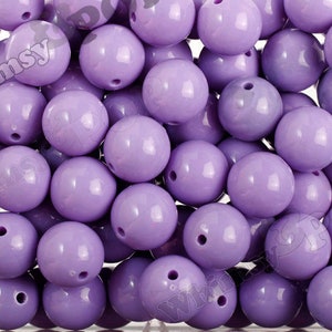 May include: A large quantity of lavender purple round beads. The beads are smooth and shiny.