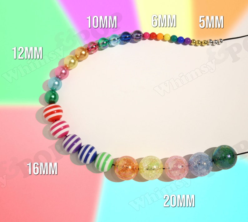 May include: A rainbow-colored beaded necklace with different sized beads, including 5mm, 6mm, 10mm, 12mm, 16mm, and 20mm beads. The beads are made of various materials, including plastic, glass, and metal.