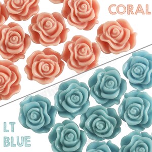 May include: A collection of coral and light blue resin rose embellishments. The roses are approximately 1 inch in diameter and have a 3D design.