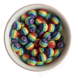 K&ouml;nnte beinhalten: Eine Sch&uuml;ssel gef&uuml;llt mit bunten Regenbogenperlen. Die Perlen sind rund und haben eine gl&auml;nzende Oberfl&auml;che.