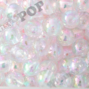 May include: A close-up image of iridescent white round beads. The beads are translucent and have a pearlescent finish.