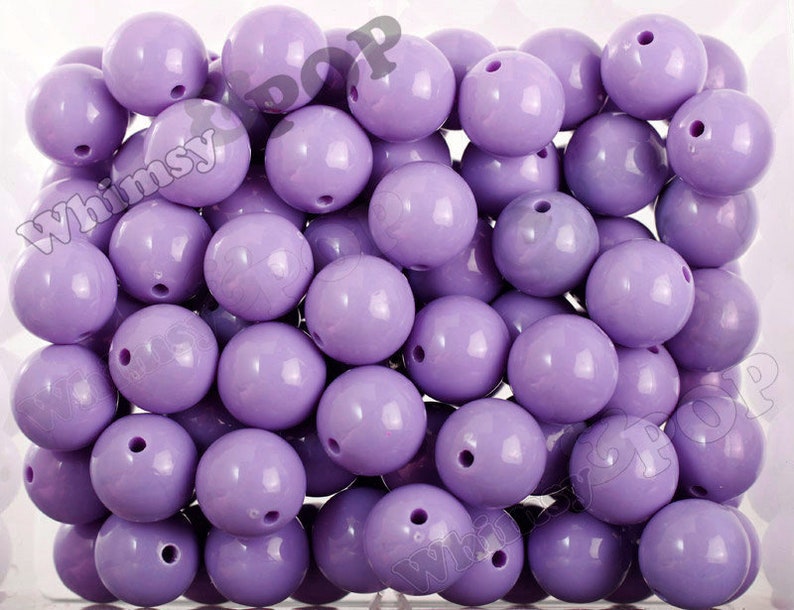 May include: A large quantity of lavender purple round beads. The beads are smooth and shiny.