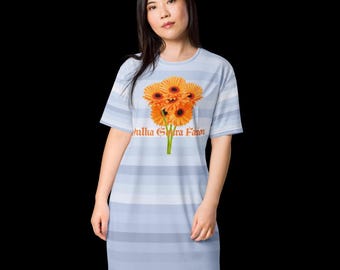 Può includere: Abito azzurro a righe orizzontali e maniche corte. L'abito presenta un bouquet di gerbere arancioni con la scritta "Julia Gra Favor" stampata sul davanti.