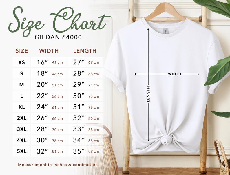Puede incluir: Una camiseta blanca Gildan 64000 cuelga de un perchero de madera, con una tabla de tallas a la izquierda. La tabla enumera las tallas XS a 5XL, con las medidas de ancho y largo correspondientes en pulgadas y cent&iacute;metros. Flechas indican el ancho y el largo de la camiseta.
