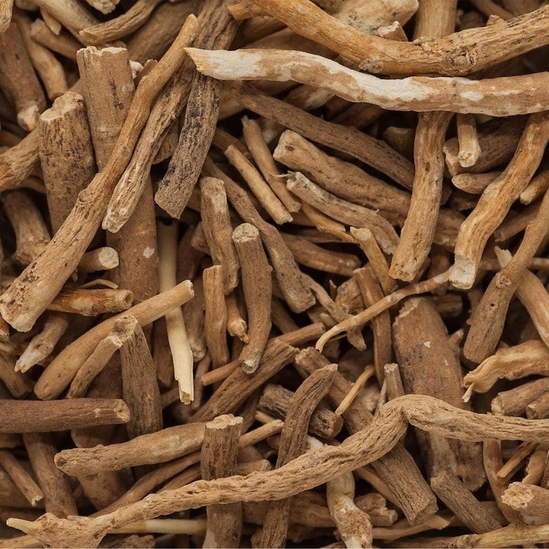 Puede incluir: Primer plano de trozos de ra&iacute;z de ashwagandha. Las piezas son de varios tama&ntilde;os y formas, con un color marr&oacute;n claro y una textura rugosa. Algunas piezas tienen una capa exterior m&aacute;s clara, casi blanca. La imagen est&aacute; bien iluminada.