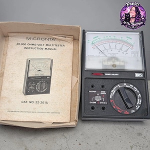 May include: A vintage Micronta 20,000 Ohms/Volt Multitester with instruction manual. The black multitester has a dial, various settings, and the text "OHMS ADJUST". The manual is in a cardboard box and has the text "MICRONTA".
