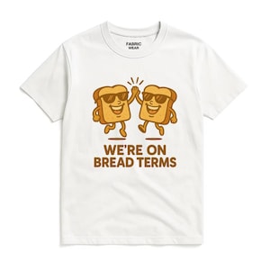 May include: White t-shirt with a graphic of two slices of bread wearing sunglasses, giving a high five. The text "WE'RE ON BREAD TERMS" is printed below the bread slices. The shirt has a Fabric Wear tag.