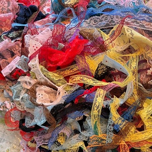 May include: A pile of colorful lace trim in various patterns and textures. The lace is a mix of white, yellow, red, blue, and black.