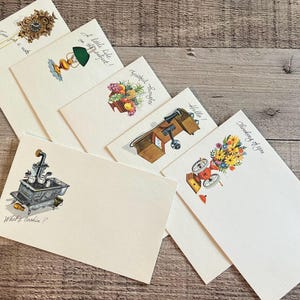 May include: A set of three ceramic mugs with a speckled, matte finish. The mugs are in shades of cream, light gray, and dark gray. Each mug has a simple, minimalist design, perfect for coffee or tea.