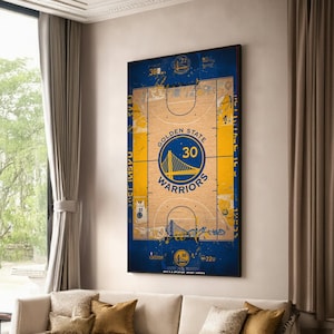 May include: A framed artwork featuring a basketball court design with the Golden State Warriors logo. The artwork is predominantly blue and gold, with the number 30 prominently displayed. The design includes the team's name and a depiction of the Golden Gate Bridge.