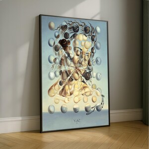 May include: Framed surrealist artwork featuring a figure composed of floating, organic shapes in shades of beige, brown, and blue. The artwork is set against a light blue background and framed in black. The artist's signature is visible at the bottom.