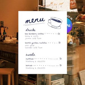 Könnte beinhalten: Eine handgeschriebene Speisekarte in einem Café. Sie listet Getränke wie Bienenblütenkaffee und Secret Garden Matcha sowie Süßigkeiten wie Muffins und Scones auf. Das Wort "Menü" steht oben, mit einer Zeichnung einer Kaffeetasse.