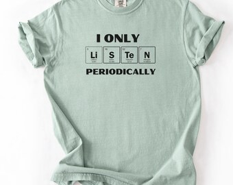 May include: A light green t-shirt with the text "I ONLY LISTEN PERIODICALLY" in black. The text is arranged to resemble a periodic table of elements, with the letters Li, S, Te, and N highlighted.