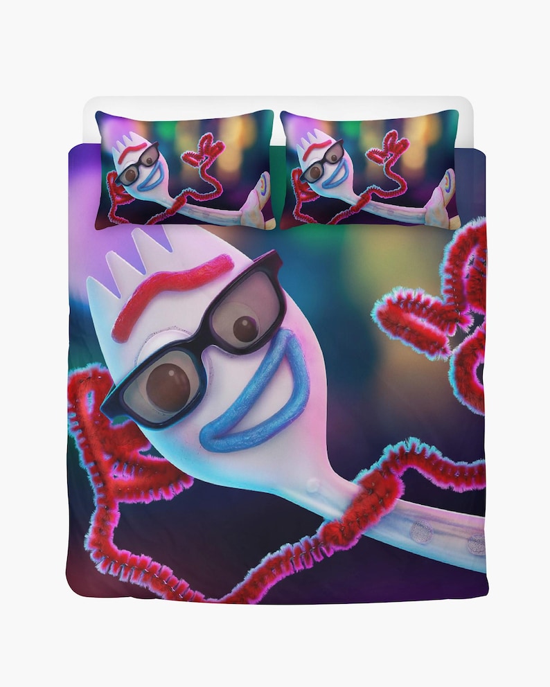 May include: Bedding set with a cartoon character design. The duvet cover and two pillowcases feature a white character with black glasses, a red pipe cleaner arm, and a blue smile. The background is a blurred mix of colours.