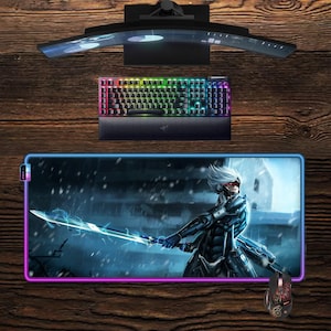 May include: A gaming setup comprising a curved monitor, a keyboard with rainbow lighting, and a large mousepad with a character illustration. A gaming mouse is also present. The items are displayed on a wooden surface.