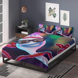 May include: A bed set with a cartoon character design. The comforter and pillowcases feature a white character with a blue mouth and black glasses. The background has a blurred, colourful effect. The bed frame is black.