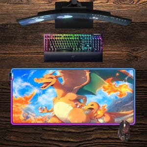 May include: Gaming setup featuring a curved monitor, a backlit keyboard, and a mouse. A large rectangular mousepad with a colorful illustration of Charizard and Charmander is the focal point. The setup is on a wooden surface.