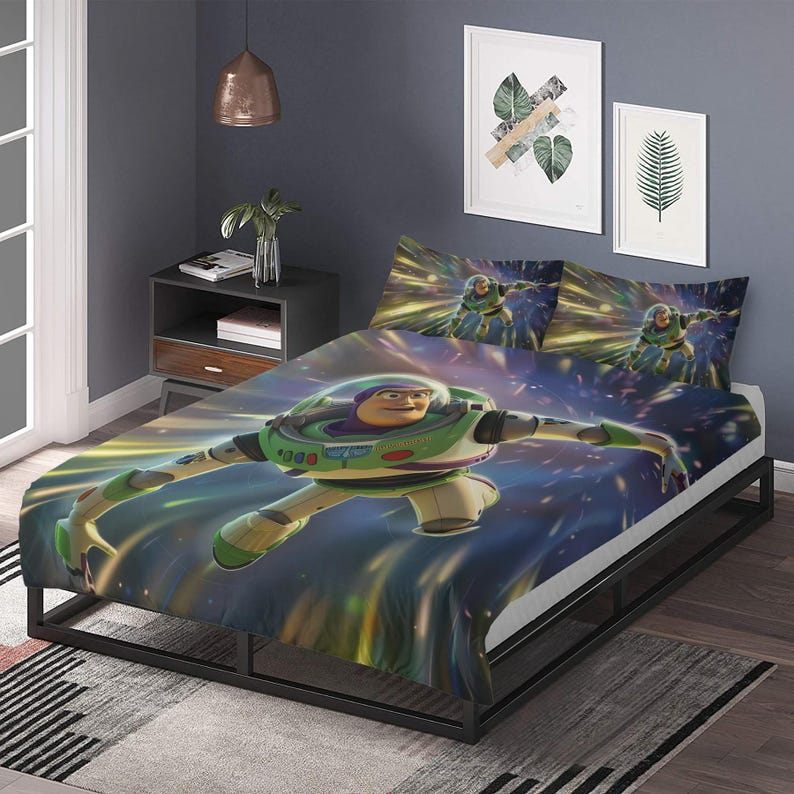Puede incluir: Juego de cama con Buzz Lightyear. La funda n&oacute;rdica y las fundas de almohada muestran una imagen din&aacute;mica de Buzz Lightyear en vuelo, sobre un fondo de estrellas y rayos de luz. La cama tiene un marco negro y la habitaci&oacute;n incluye obras de arte enmarcadas.
