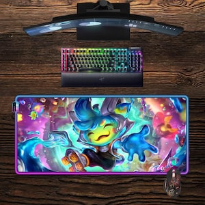 May include: A gaming setup with a curved monitor, a keyboard with rainbow lighting, and a large mousepad with a cartoon character design. A matching mouse is also included. The setup is on a wooden surface.