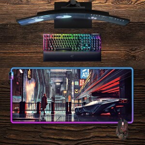 Può includere: Un monitor per computer curvo, una tastiera con illuminazione arcobaleno, un mouse e un ampio tappetino per mouse con un design di città futuristica. Il tappetino per mouse ha un bordo luminoso. La tastiera e il mouse sono neri.