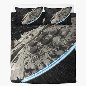 Könnte beinhalten: Bettwäsche-Set mit einem detaillierten Bild eines Raumschiffs. Das graue Raumschiff mit kreisförmigen Details und blau leuchtendem Rand ist auf zwei Kissenbezügen und einer Bettdecke vor schwarzem Weltraumhintergrund abgebildet.