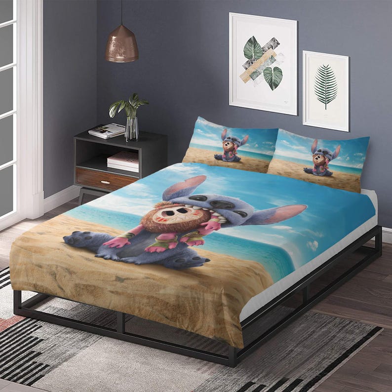 May include: A blue and white bed set featuring a cartoon character on a beach scene. The set includes a fitted sheet, two pillowcases, and a comforter. The comforter and pillowcases have a blue sky and ocean background.