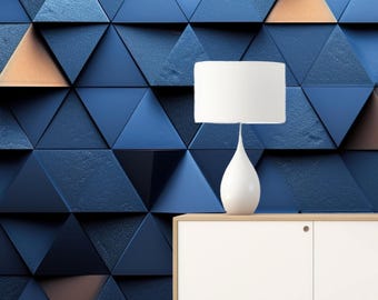 May include: A white lamp with a cylindrical shade and a teardrop-shaped base sits on a white cabinet with a light wood top. The background features a wall of blue and bronze triangular tiles.