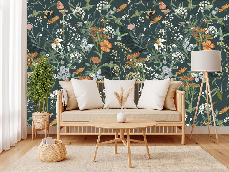 May include: A living room scene featuring a floral wallpaper with butterflies, flowers, and foliage in shades of green, orange, and white. A light-colored wooden sofa with white pillows, a round coffee table, and a floor lamp complete the decor.