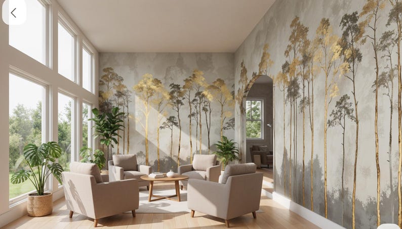 May include: A modern living room with large windows and a mural featuring gold and gray trees. The room includes four beige armchairs, a round wooden coffee table, and potted plants. The walls are painted in neutral tones, creating a serene atmosphere.