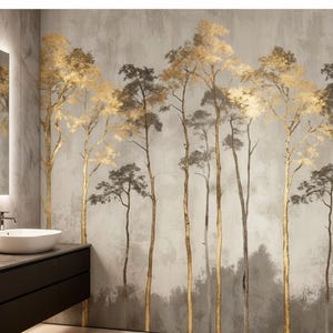 May include: A bathroom with a modern design featuring a wall mural of stylized trees. The trees have gold and gray foliage and trunks against a muted gray background. The bathroom includes a dark brown vanity with two white vessel sinks and a large mirror.