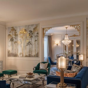 May include: An elegant living room with a sunburst mirror, artwork of trees, and a blue velvet sofa. The room features a chandelier, lamps, and a mirrored cabinet, creating a luxurious and inviting atmosphere.