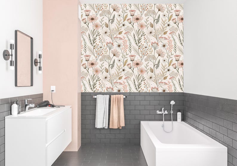 May include: A bathroom with a white bathtub, sink, and floral wallpaper. The wallpaper features a repeating pattern of beige, pink, and brown flowers and foliage. The walls are painted in white and pink, with dark gray tile accents.
