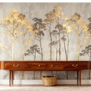 May include: A long, dark wood console table with three drawers and a woven basket beneath a wallpaper mural of stylized trees in gold and gray tones. The room has white trim and a light-colored rug.