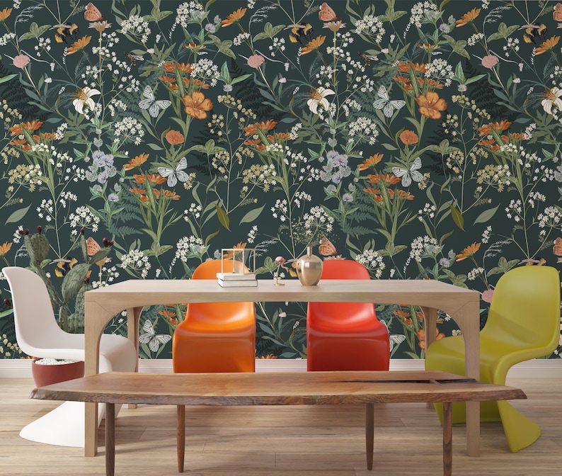 May include: A dining room scene featuring a wooden table and chairs. The chairs are in various colors: white, orange, and yellow. The background is a dark floral wallpaper with butterflies and flowers in shades of orange, white, and green.
