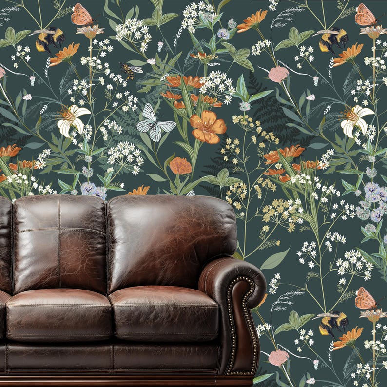 May include: A dark green floral wallpaper featuring orange, white, and yellow flowers, butterflies, and bees. A brown leather sofa is in the foreground. The wallpaper has a botanical theme.