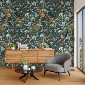 May include: A dark green floral wallpaper featuring a pattern of white, orange, and purple flowers, along with butterflies. The wallpaper is the backdrop for a wooden cabinet, a gray armchair, and a black coffee table.
