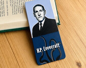 May include: A rectangular bookmark featuring a portrait of H.P. Lovecraft in a black suit against a light blue background. The lower section is dark blue with black tentacles and the white text H.P. Lovecraft printed across the center.