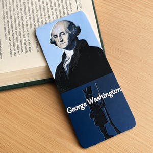 May include: A rectangular bookmark featuring a portrait of George Washington in a black coat against a light blue background on the top half, and a dark blue bottom half with a silhouette of a soldier and the text George Washington in white.