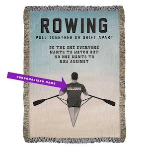 May include: Woven throw blanket with a rowing theme. The design features a rower, oars, and the word "ROWING" in large letters. Text includes "PULL TOGETHER OR DRIFT APART" and "BE THE ONE EVERYONE WANTS TO WATCH BUT NO ONE WANTS TO ROW AGAINST."