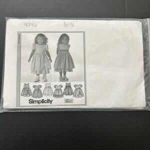 Puede incluir: Un sobre de patrón de costura Simplicity marcado con 4296 y 1/2-4, dentro de una funda de plástico transparente. El frente muestra ilustraciones en blanco y negro de niños con varios diseños de vestidos, incluyendo faldas fruncidas y cinturillas.