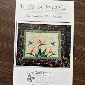 May include: A wall hanging quilt pattern titled "Birds in Paradise." The quilt design features a central image of stylized birds and flowers, with the text "HOPE IS THE THING WITH FEATHERS." The pattern includes paper foundation sheets.