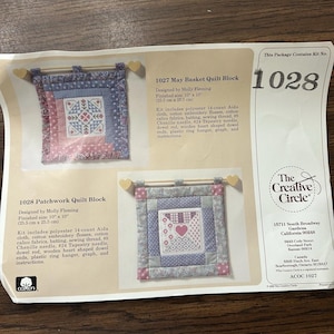 May include: Two quilt block kits, designed by Molly Fleming, are displayed. Each kit includes fabric, floss, and a dowel rod for hanging. The finished size of each quilt block is 10" x 10". The kits are from The Creative Circle.