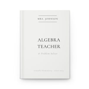 May include: A white journal with the text "MRS. JOHNSON" at the top, followed by "ALGEBRA TEACHER & Problem Solver" and "Lincoln Elementary since 2015". The journal is closed and has a clean, minimalist design.