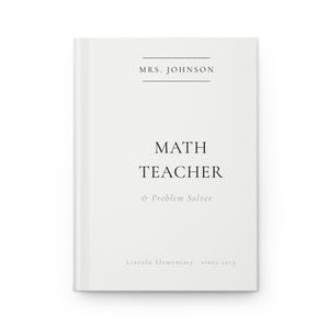 May include: A white notebook with the text "MRS. JOHNSON" at the top, followed by "MATH TEACHER & Problem Solver" in the center. The bottom of the notebook reads "Lincoln Elementary - since 2015".