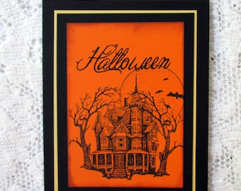 May include: A black and white illustration of a spooky house with a large porch and trees on an orange background. The text "Halloween" is written in a cursive font at the top of the image.