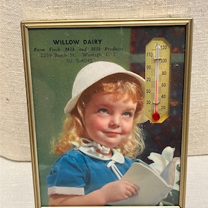 May include: Framed vintage advertisement for Willow Dairy. The image features a young girl in a blue dress and white hat, holding a book. A thermometer is superimposed on the image. The frame is gold-colored, and the text includes the dairy's name and address.