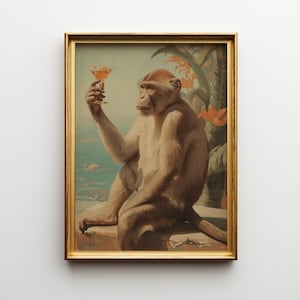 Könnte beinhalten: Ein gerahmter Kunstdruck, der einen hellbraunen Affen zeigt, der sitzt und ein orangefarbenes Cocktailglas hält. Der Hintergrund zeigt ein blaues Meer und orangefarbene tropische Blumen. Das Bild ist in einem dünnen, goldfarbenen Rahmen.