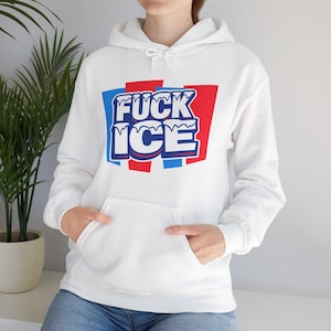 Puede incluir: Sudadera con capucha blanca con bolsillo delantero y cordón. El gráfico en la parte delantera dice "FUCK ICE" en texto azul y blanco con un fondo rojo.