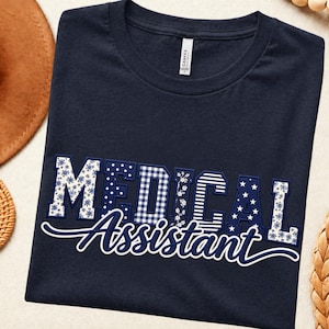 May include: A navy blue t-shirt featuring the text MEDICAL ASSISTANT. The word MEDICAL is written in large block letters with varied patterns including floral, polka dot, gingham, and stripes. The word Assistant is in white cursive script.
