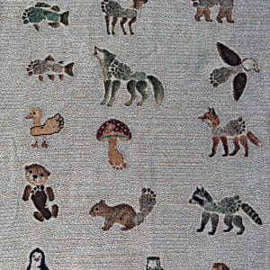 May include: A woven throw blanket featuring a light grey background with a repeating pattern of various animals including a deer, wolf, bear, fox, raccoon, squirrel, otter, penguin, lion, duck, and fish, alongside a mushroom and a small green tractor.